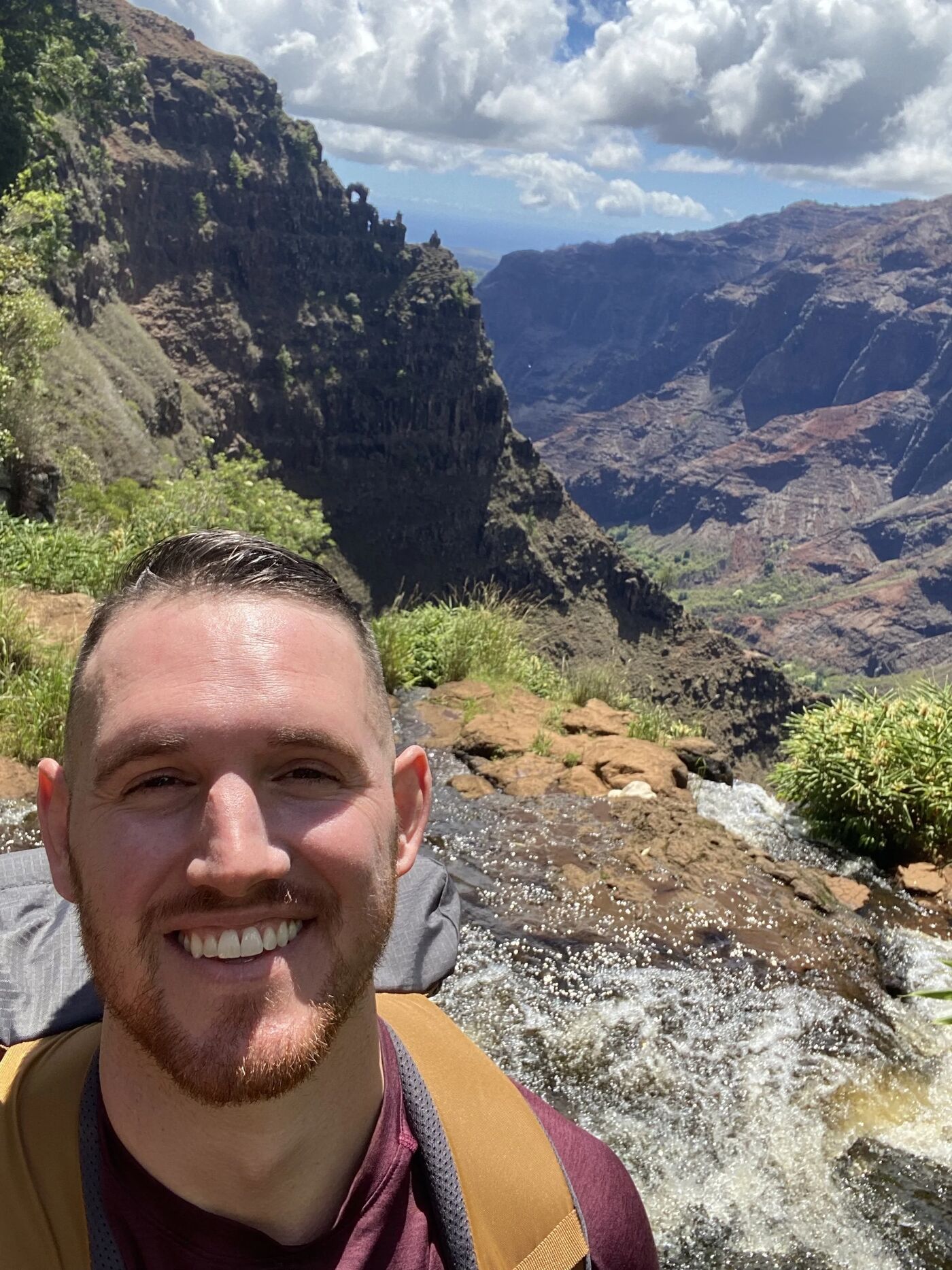 Dr. Kyle Pratt smiling outdoors in front of a Colorado canyon and stream